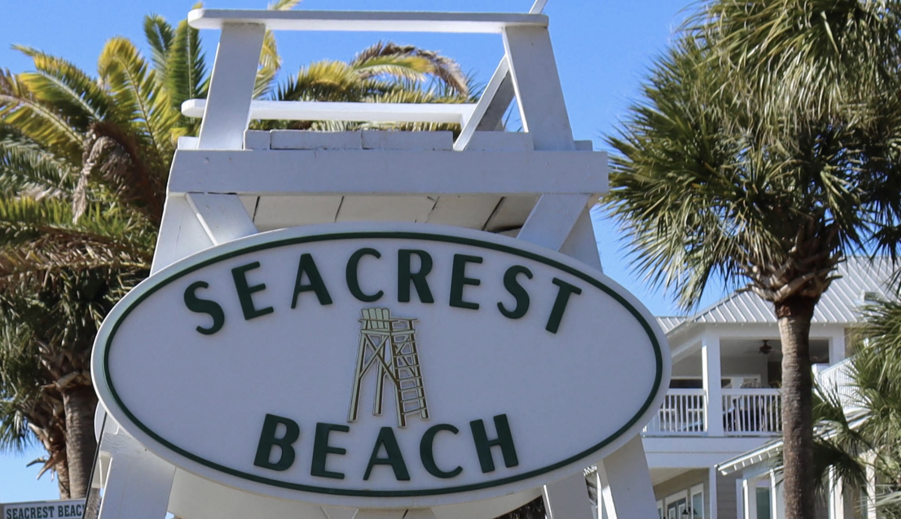 Seacrest Beach Florida entrance sign surrounded by palm trees along Scenic Highway 30A