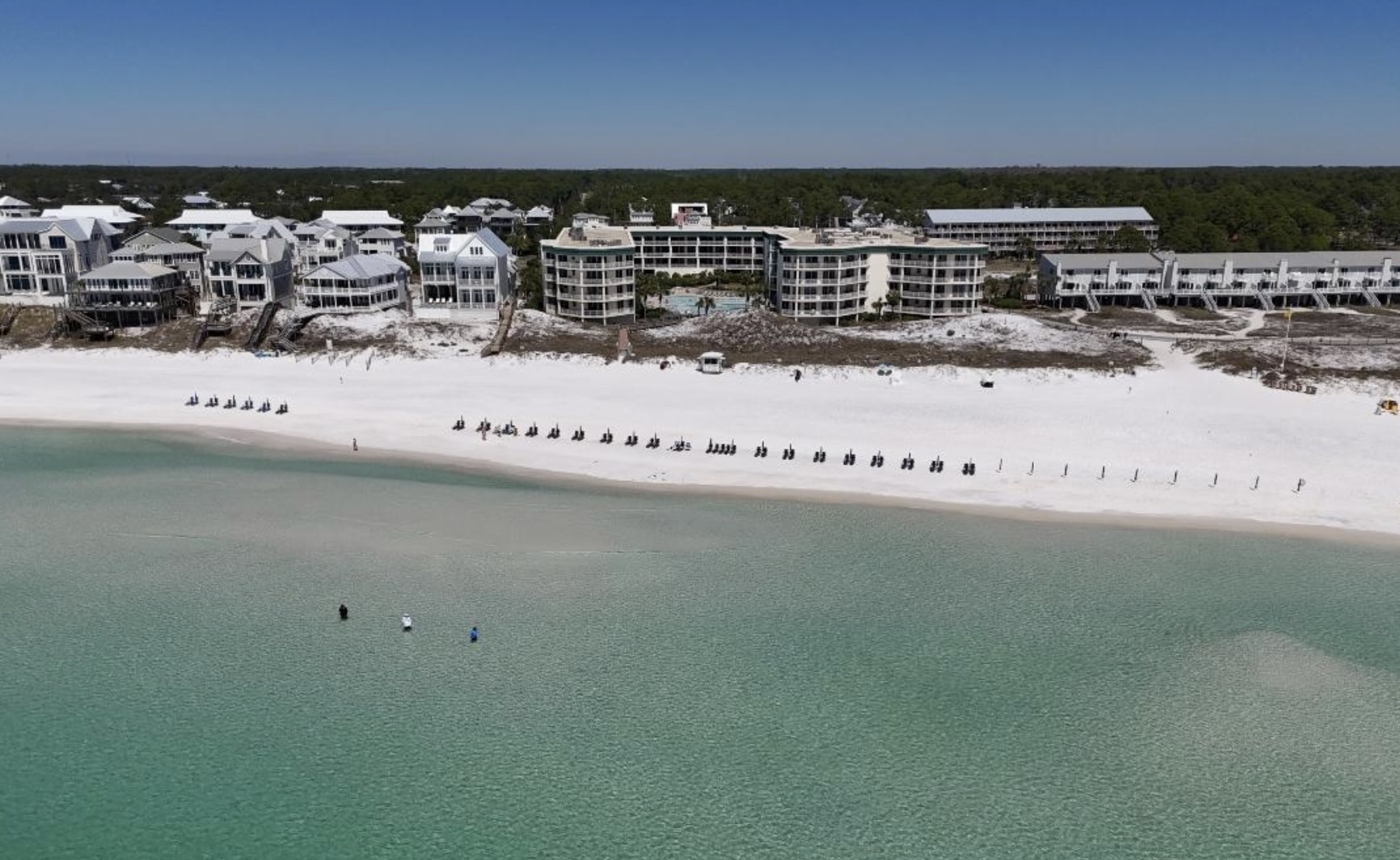 Aerial view of Seagrove Beach, Florida showing white sand shoreline, emerald green Gulf waters, and beachfront homes along Scenic Highway 30A.