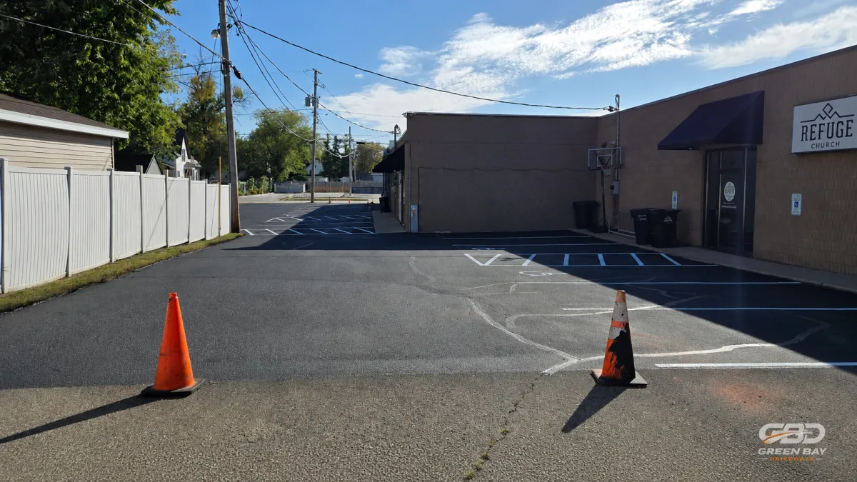 Rear driveway with parking stalls freshly sealcoated and striped for markings