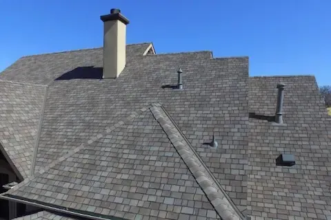 Multi-pitch asphalt shingle roof with chimney and pipe vents completed by Brooklyn Park Roofing Co