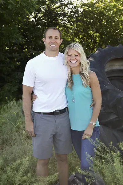 Travis King land flipping coach standing outdoors with Becca King