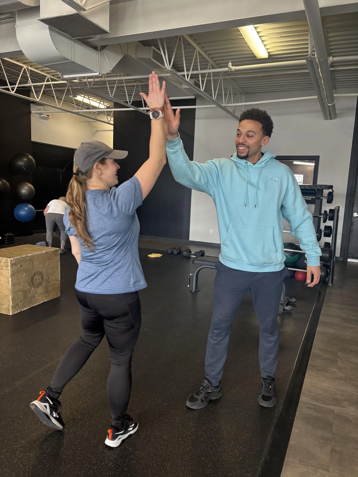 Un adulte souriant termine une séance d’entraînement avec calme et confiance, illustrant une approche réaliste, durable et constante de la santé et de l’entraînement.