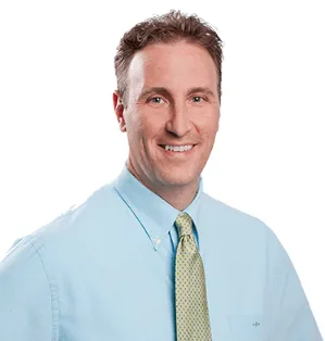 A professional headshot of Dr. Michael, smiling confidently with a white background.