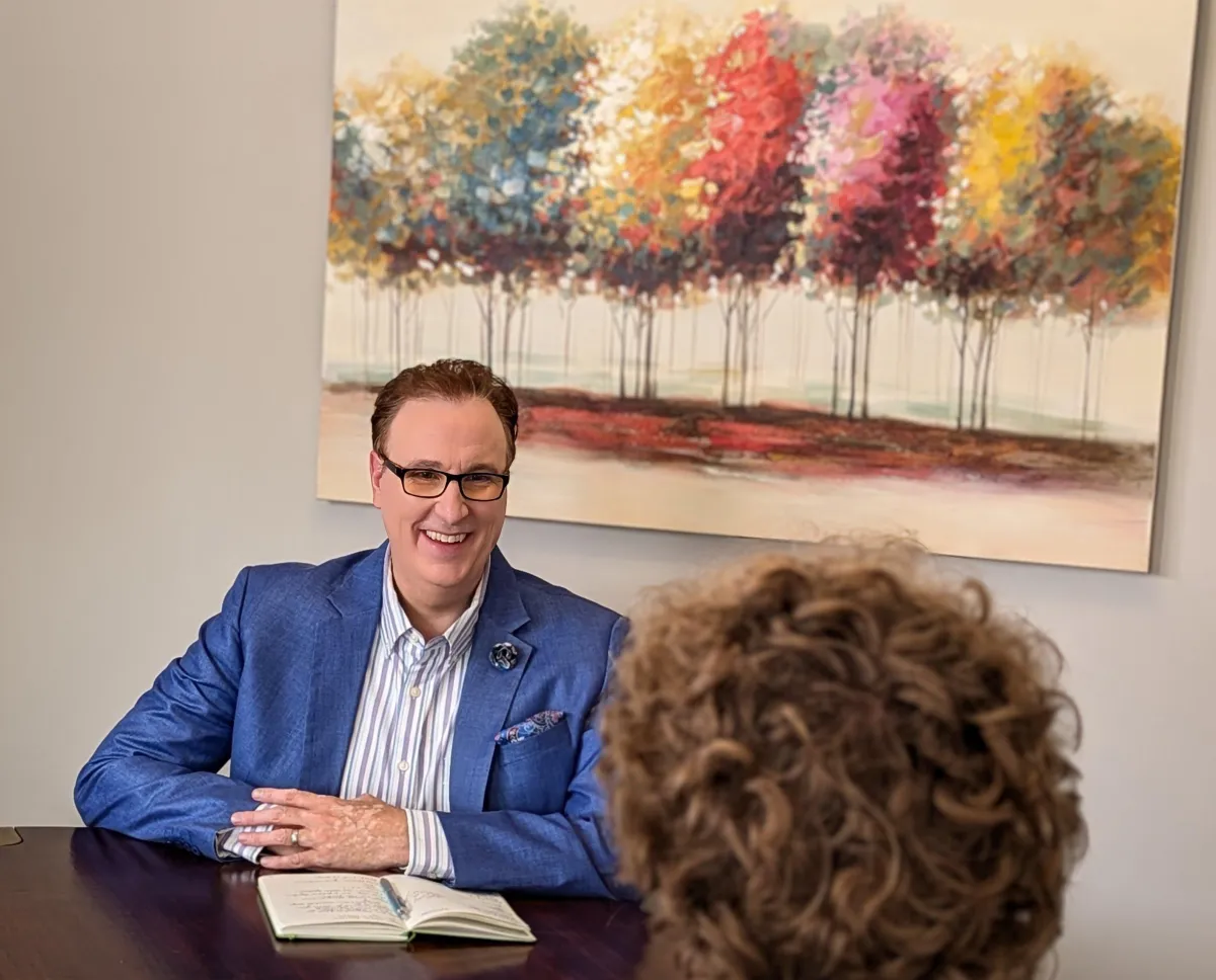 Dr. Michael smiles while speaking with a patient, showing a warm and attentive demeanor during their conversation.