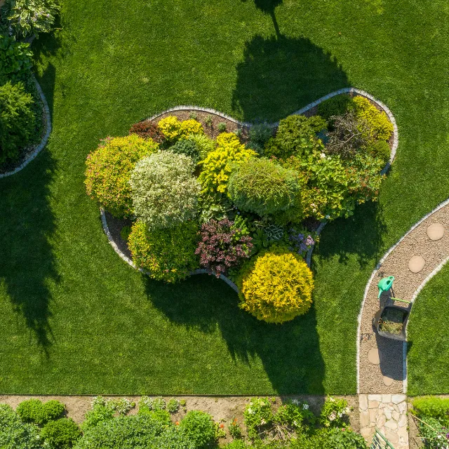 Aerial view of planted garden island with established shrubs surrounded by lawn in Bromsgrove