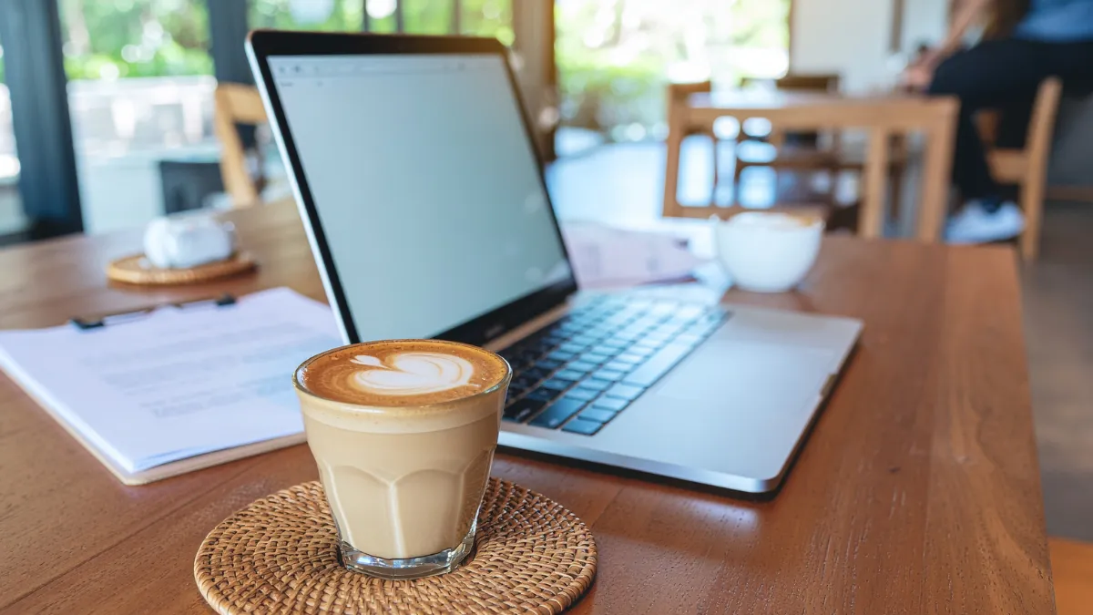 Bookkeeper meeting client over coffee with laptop open discussing business finances