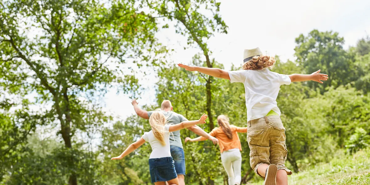 Family walking together outdoors, encouraging conversation, wellbeing and family bonding.