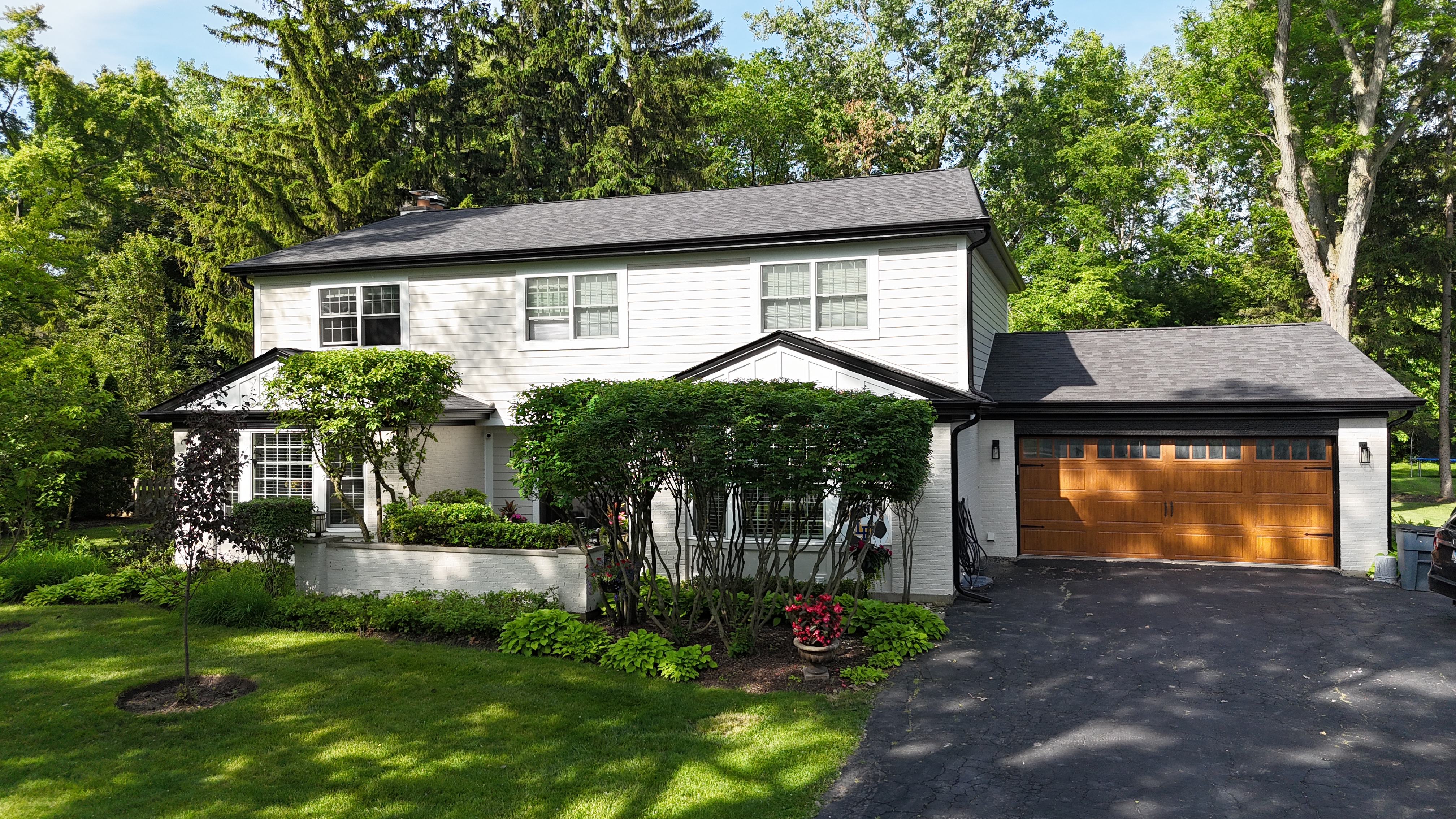 Cobblestone James Hardie siding with Arctic White trim, black soffit, fascia, and gutters, paired with Illinois' first Malarkey Brilliant Black roof, installed on a Lake Forest, IL home by Northwind Exteriors.