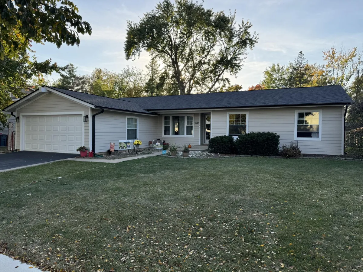 Cobblestone James Hardie siding with Arctic White trim, black soffit, fascia, and gutters, paired with a Malarkey Brilliant Black roof, installed on a home in Elk Grove Village, IL by Northwind Exteriors.