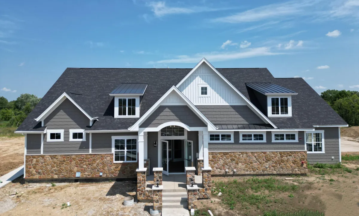 New construction project in Lake Geneva, Wisconsin by Northwind Exteriors featuring Gray James Hardie siding with Arctic White trim for a sleek, modern, and durable home exterior.