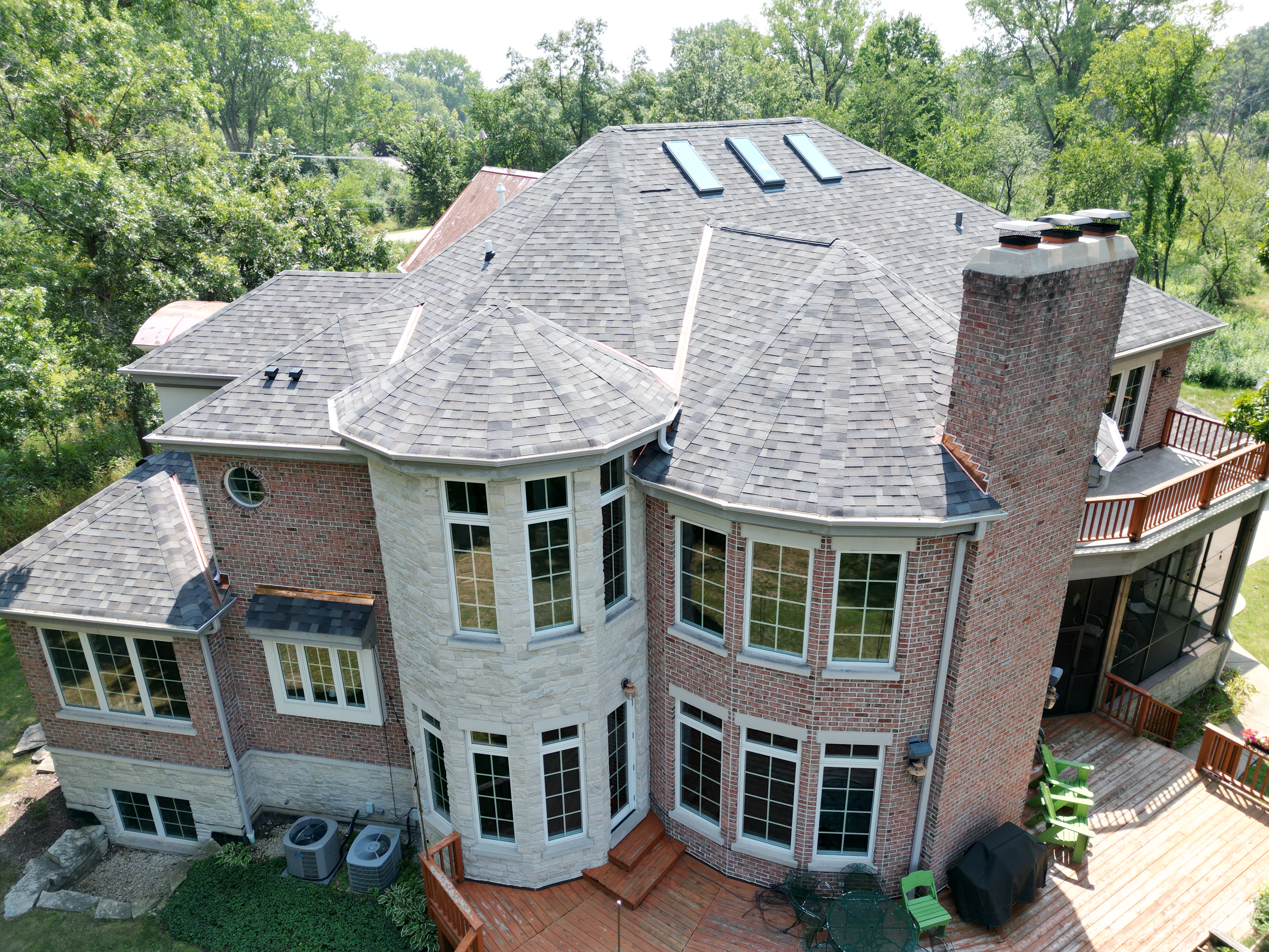 Malarkey Storm Gray shingle roof paired with a large custom copper roof installed by Northwind Exteriors in Riverwoods, IL, showcasing a seamless blend of style and function.