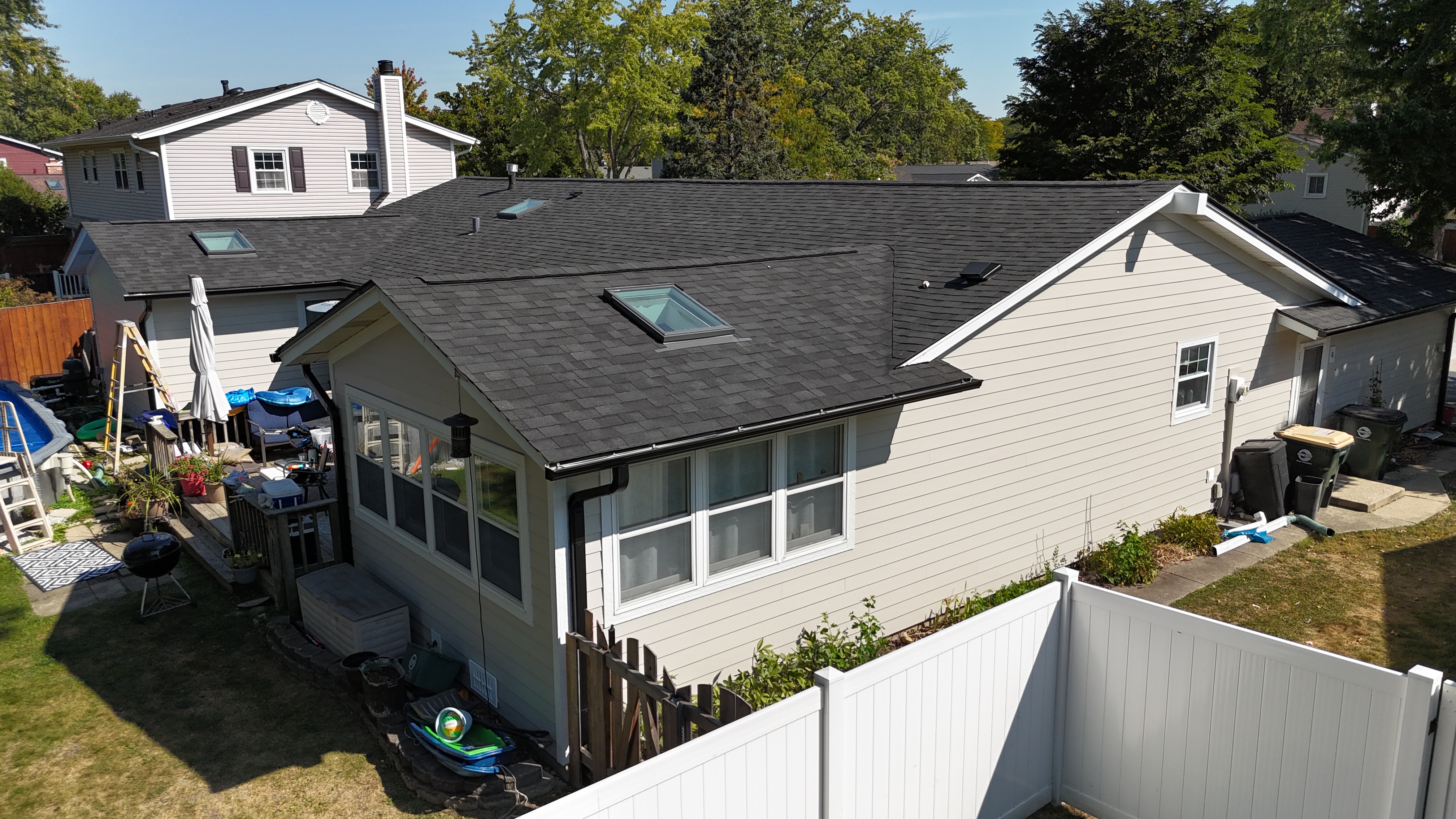 Malarkey Brilliant Black shingle roof installed by Northwind Exteriors in Elk Grove, IL, complemented by black gutters and James Hardie Cobblestone siding for a cohesive, modern look.