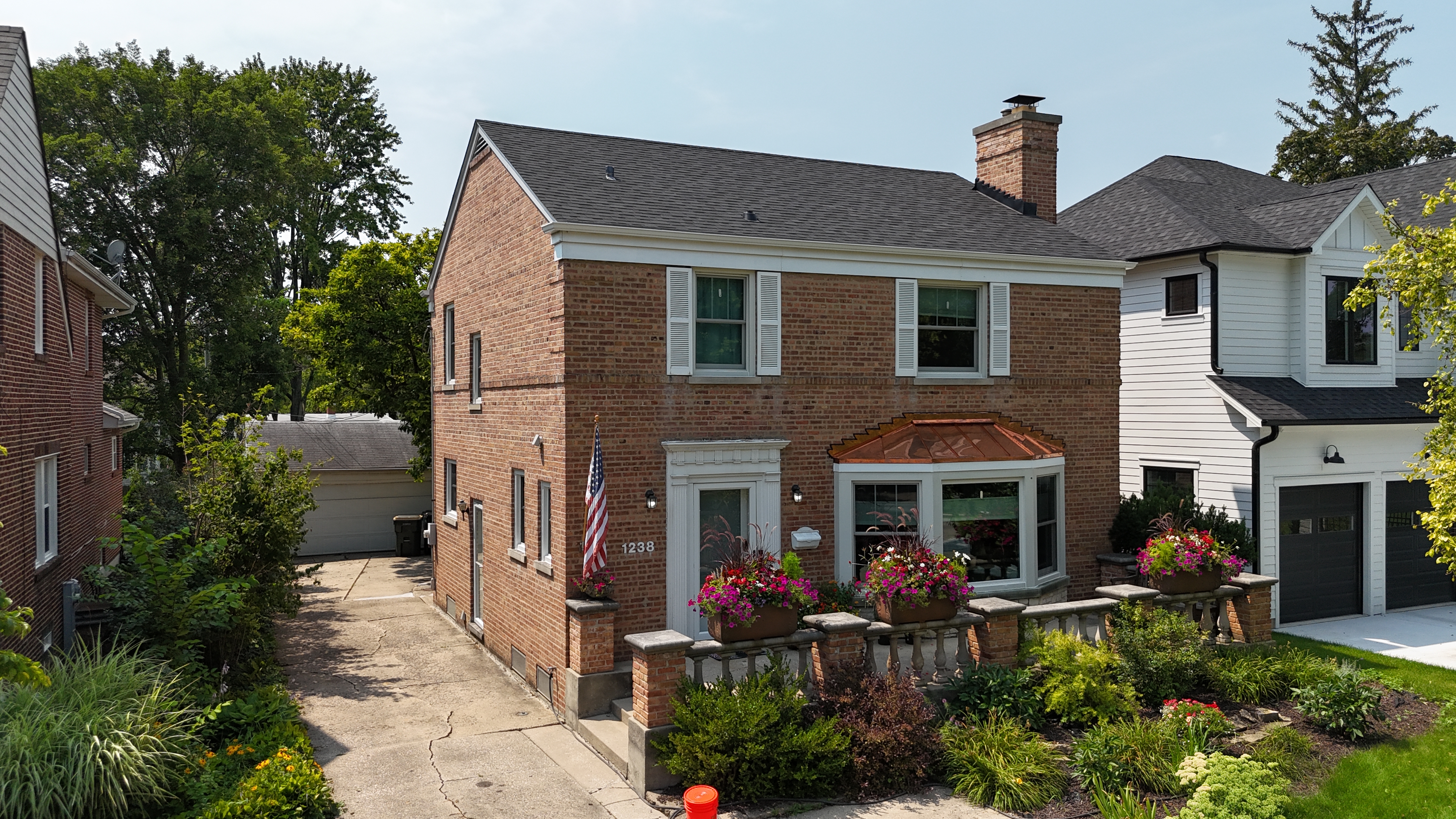 Malarkey Brilliant Black shingle roof installed by Northwind Exteriors on a Georgian-style home in Park Ridge, IL, featuring a custom copper bay window roof for added elegance.