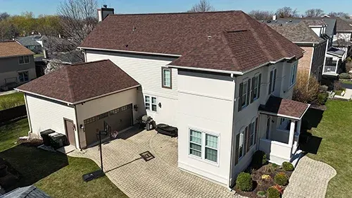 Navajo Beige James Hardie siding paired with a Malarkey Antique Brown roof installed on a home in Park Ridge, IL by Northwind Exteriors.