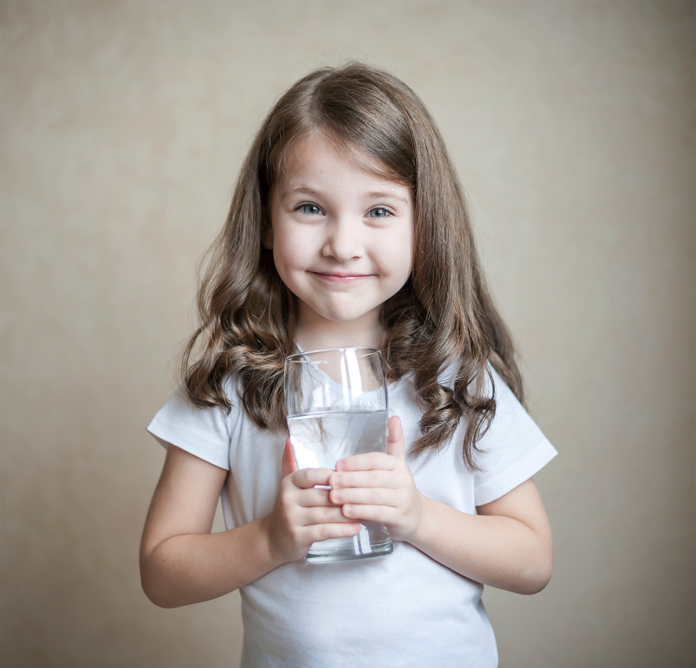3D render of a bright family kitchen with a digital-style Living Water Source filtration system glowing soft blue, parents and kids happily filling glasses with crystal-clear water.
