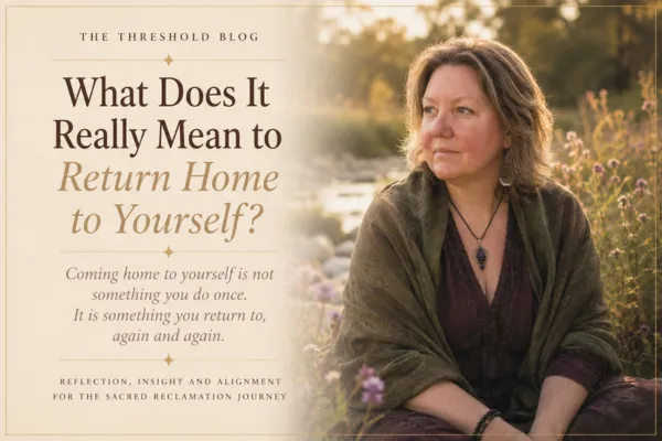 Woman in a golden autumn field beside a stream, wrapped in a shawl and gazing into the distance, cover image for the blog What Does It Really Mean to Return Home to Yourself?