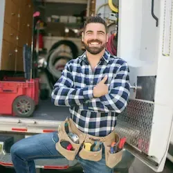 A contractor smiling at his truck as he is busy working with clients because of his marketing