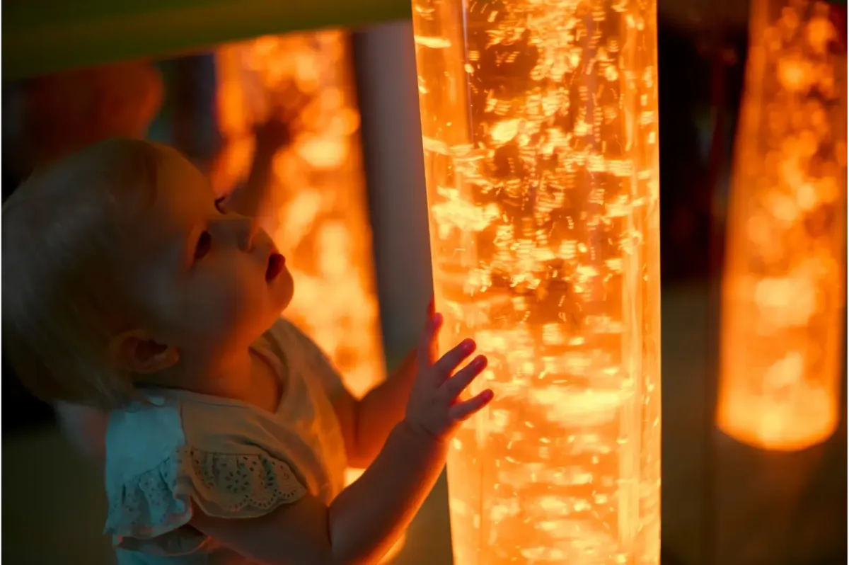 Child crawling through a red tunnel in the indoor soft play area