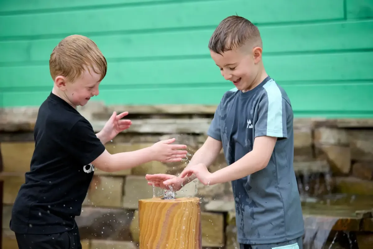 Outdoor adventure play area with climbing frame and water play