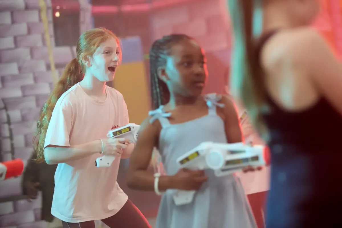 Children having fun playing laser tag in a bright indoor play environment