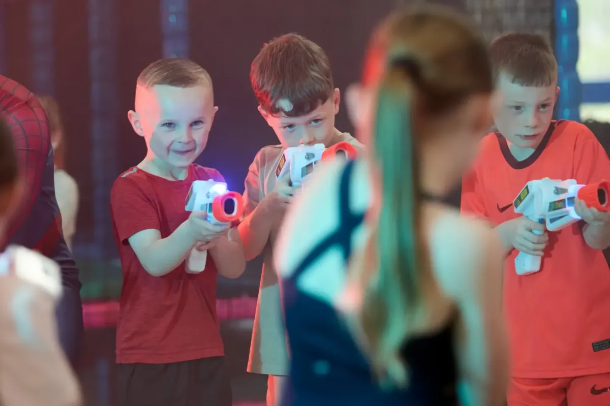 Older children enjoying an interactive laser tag party inside a dynamic arena