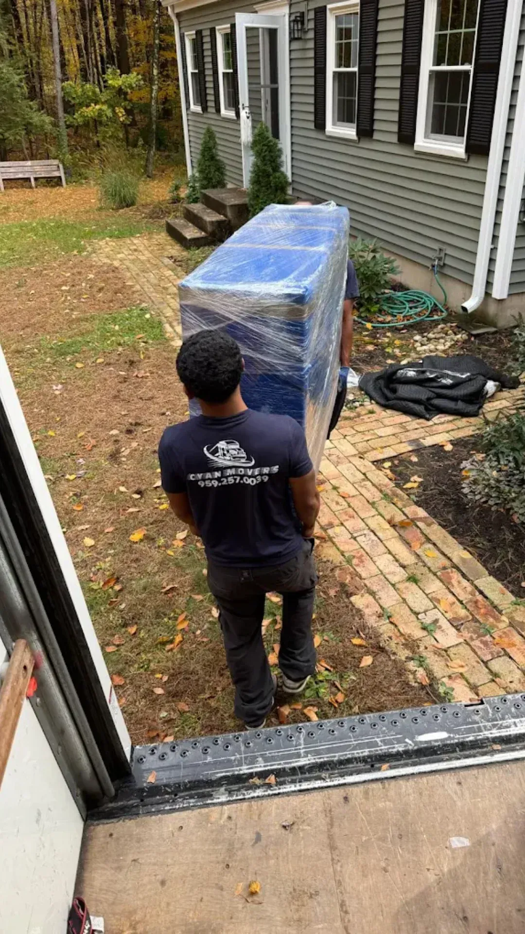 Professional mover delivering wrapped furniture to a home during a residential move in Connecticut