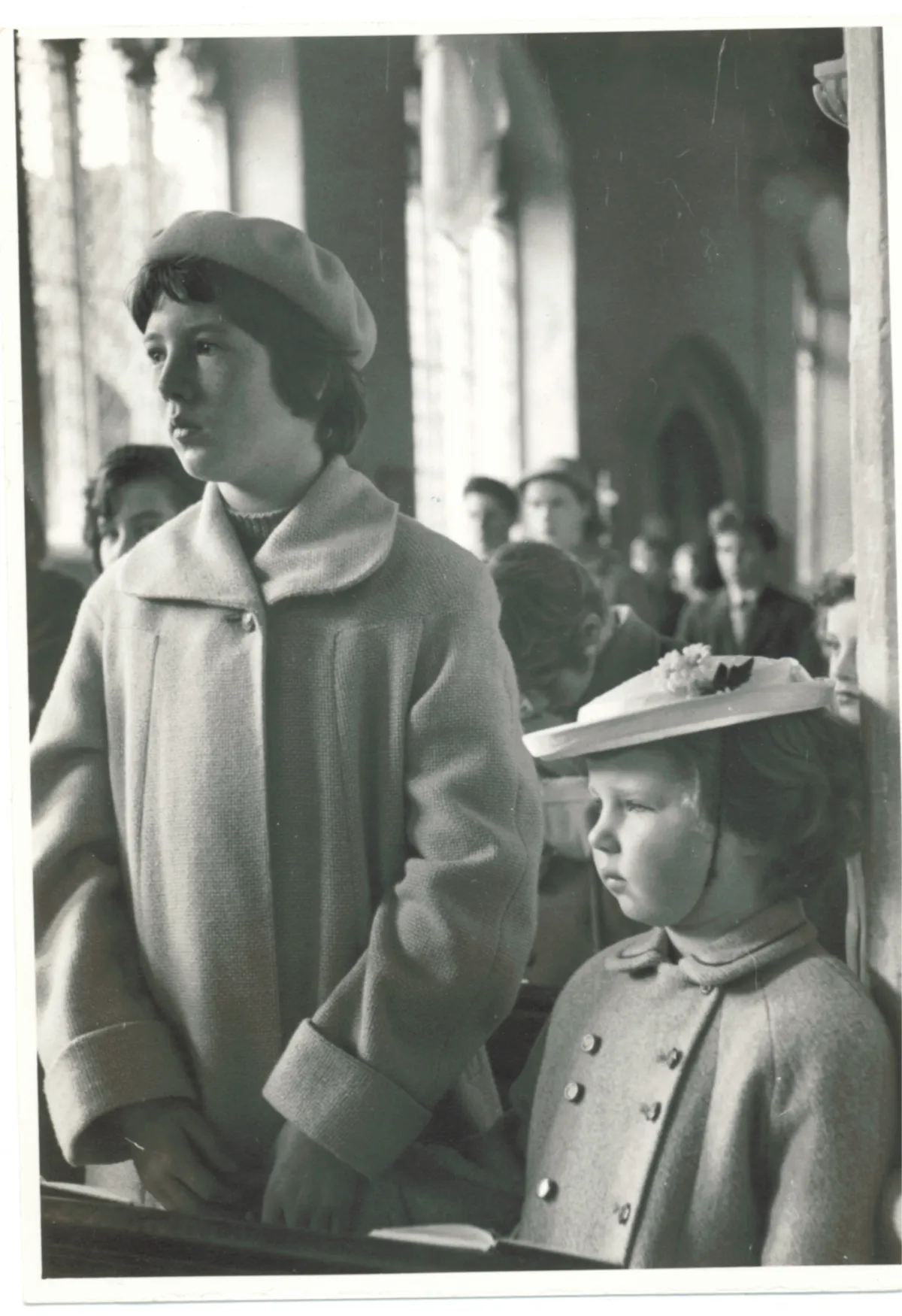 Dot Harvey laughing with her grandchildren in a sunlit backyard, surrounded by blooming flowers and greenery. The candid moment captures joy and warmth, with everyone smiling and embracing, reflecting the love and closeness of family bonds.