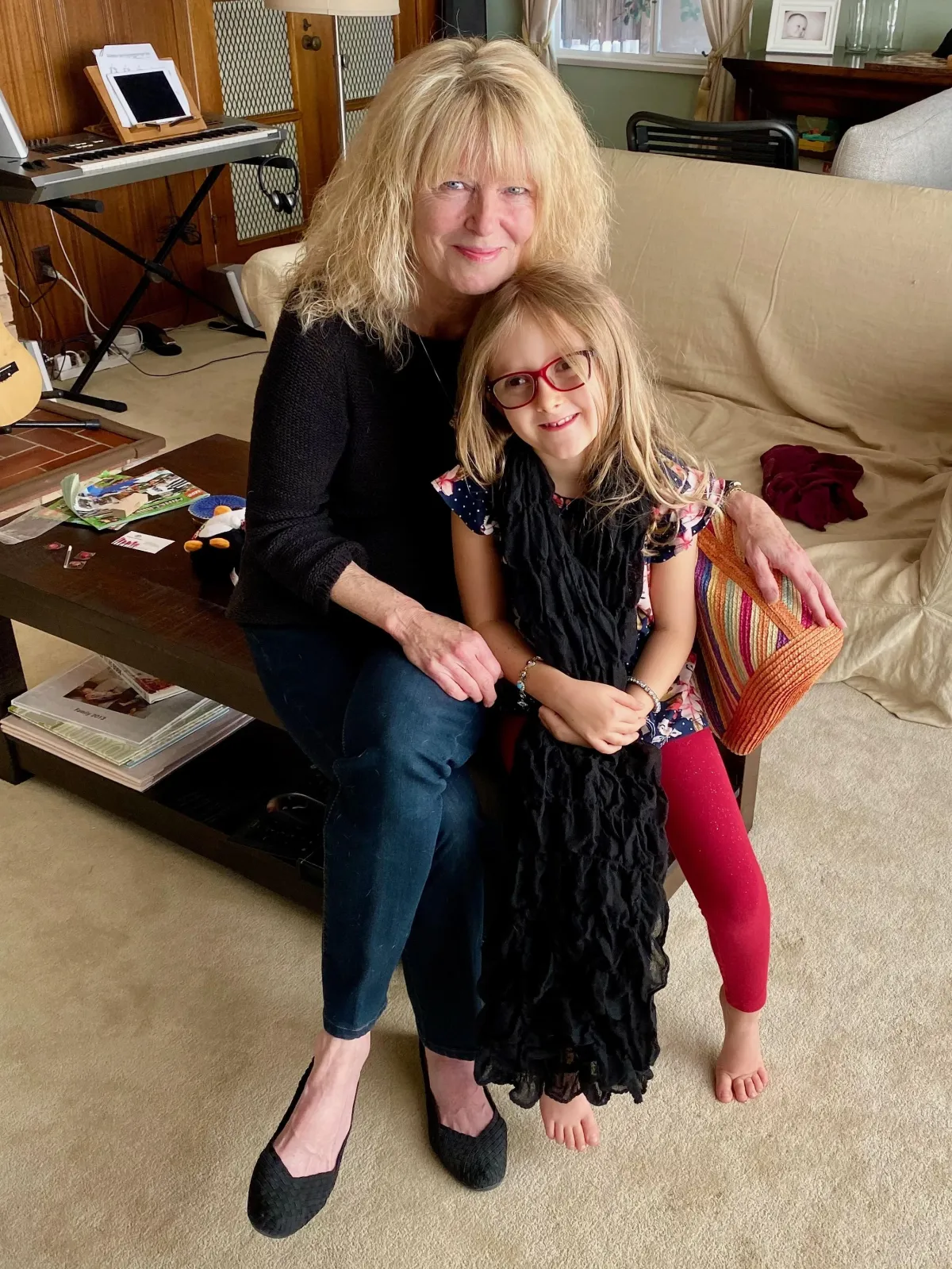 Dot Harvey tending to her vibrant garden, kneeling among colorful flowers and lush plants. She wears a straw hat and gardening gloves, her face lit with a gentle smile. The scene is bright and lively, showcasing her passion for nature and nurturing life.