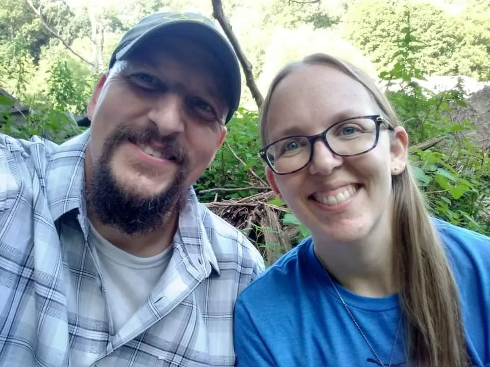 a man standing in front of a stone wall