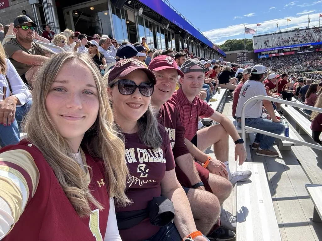 The Nelson family hiking in a forest, smiling and holding hands on a leafy trail