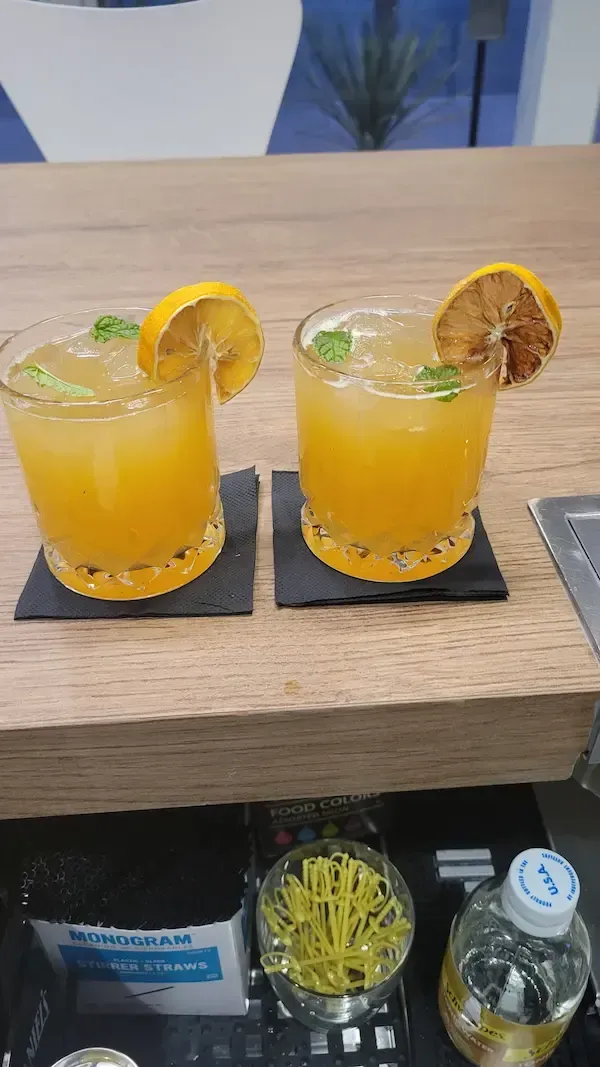 Two signature orange cocktails with dried lemon and mint, by Las Vegas mobile bartender Lesley Gillett