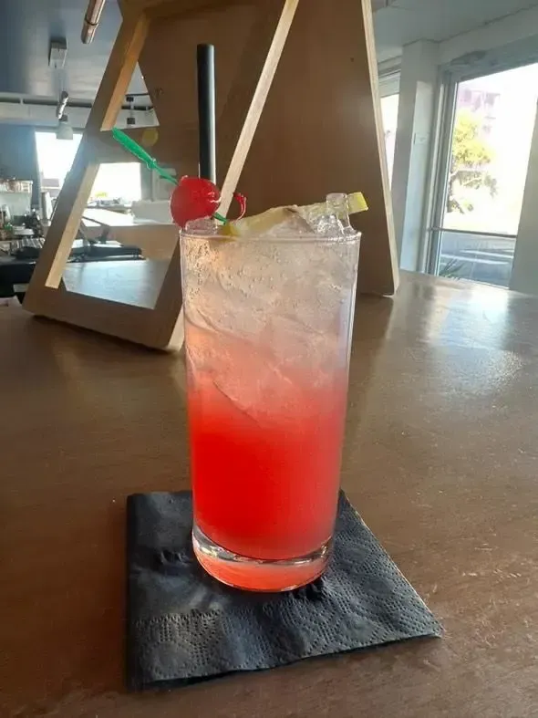 Vibrant red layered cocktail garnished with cherry and lemon twist, Avilez Mobile Bar Las Vegas