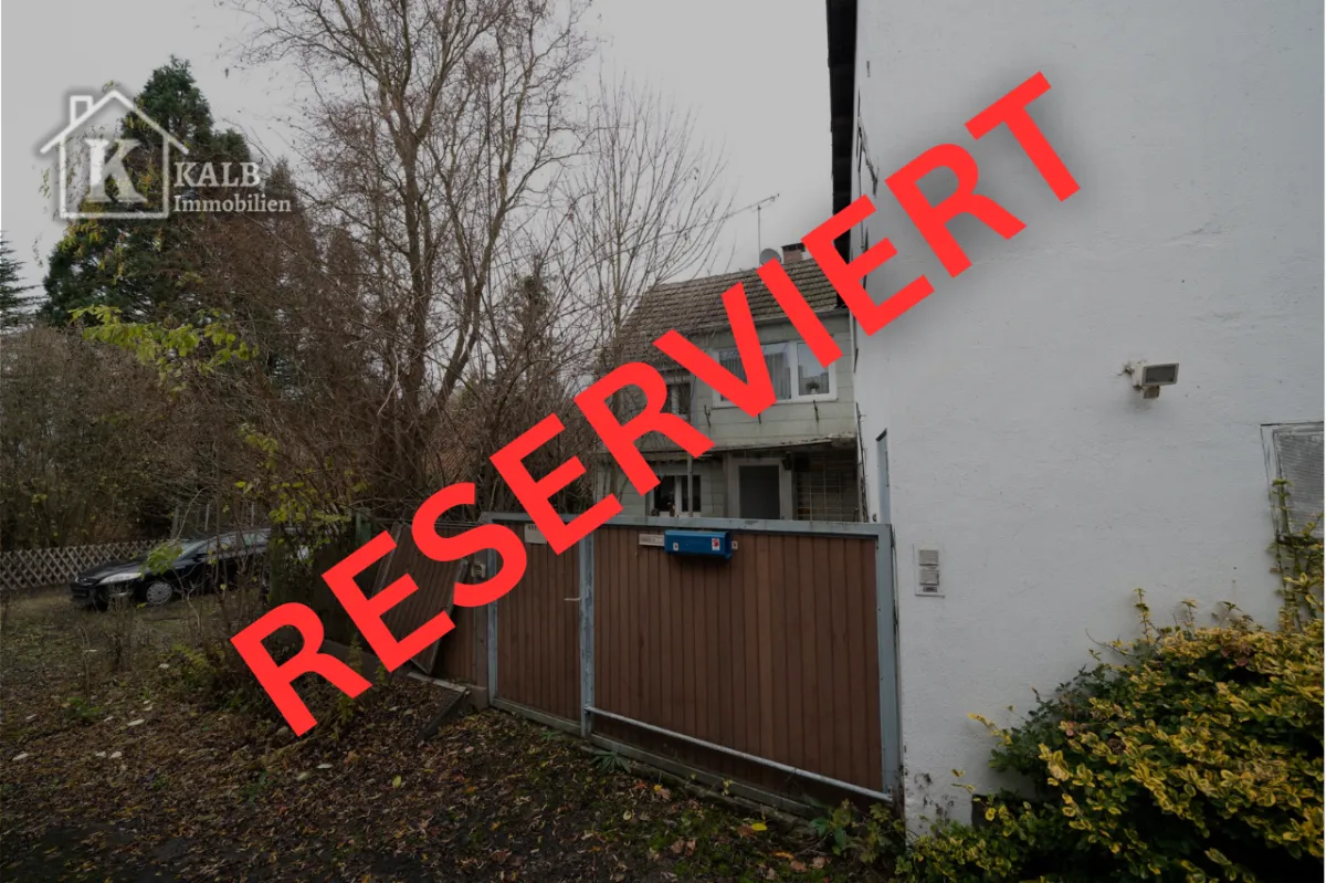 Zugang zum Grundstück mit Holz- und Metalltor, umgeben von Bäumen und Sträuchern. Außenbereich in naturbelassenem Zustand mit Renovierungsbed