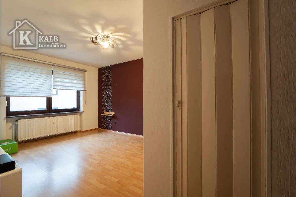 Helles Schlafzimmer der 3-Zimmer-Wohnung in Niederwerrn mit großem Fenster und Laminatboden