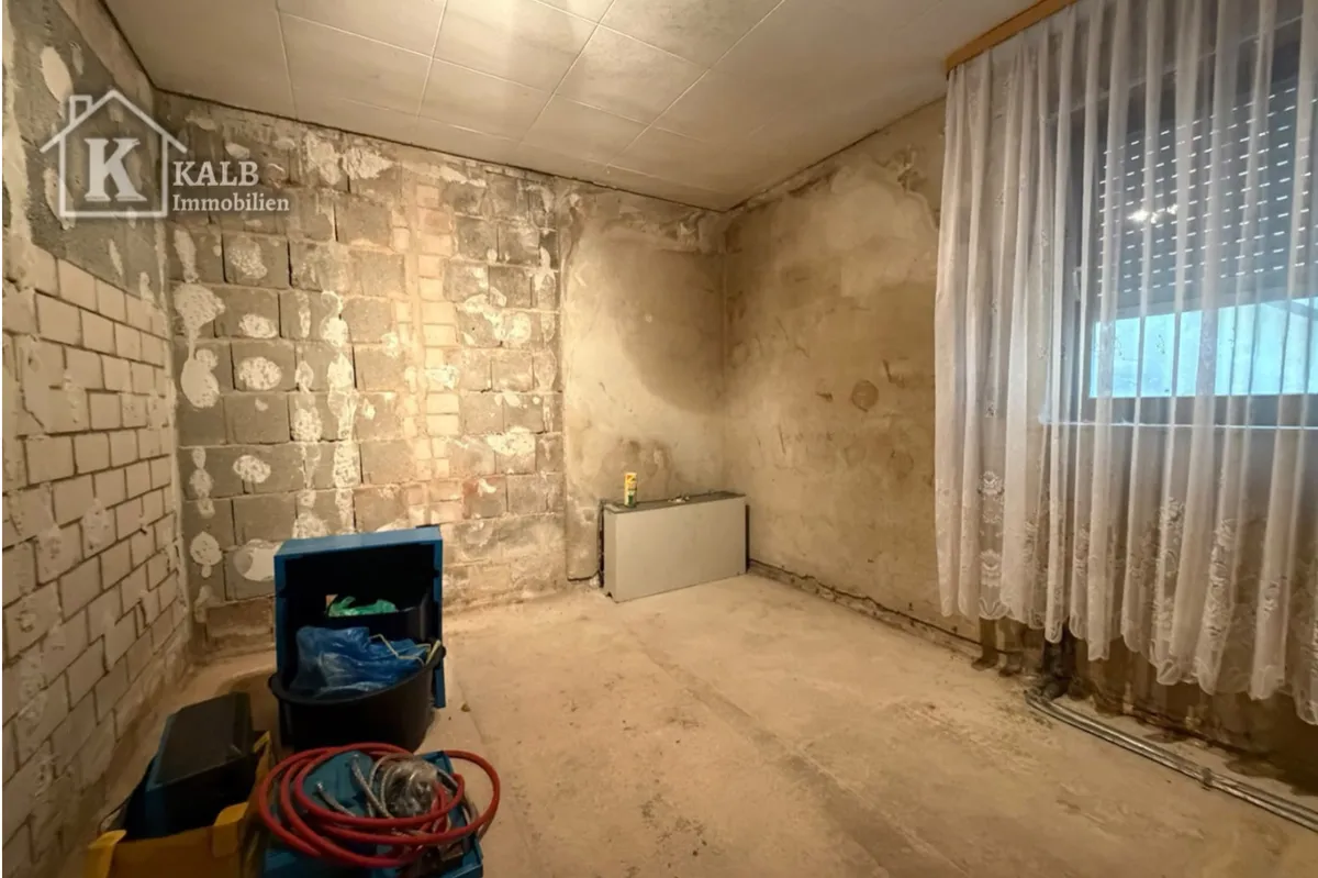 Innenraum mit freigelegten Wandflächen und Fenster im sanierungsbedürftigen Haus in Eltmann