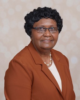Rev. Dr. Loretta Faye Baker leading a small Bible study in a bright cozy living room.