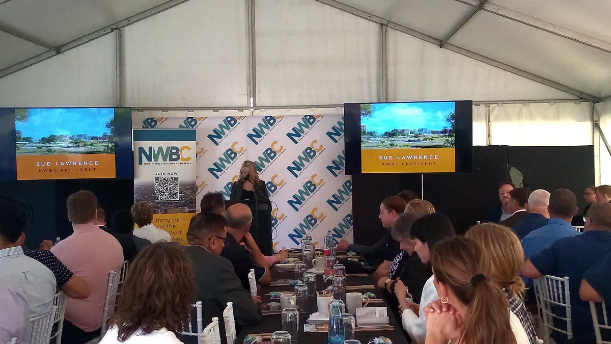 Dual 75 inch 4K LED monitors on tall floor stands with a branded media wall and professional corporate lectern