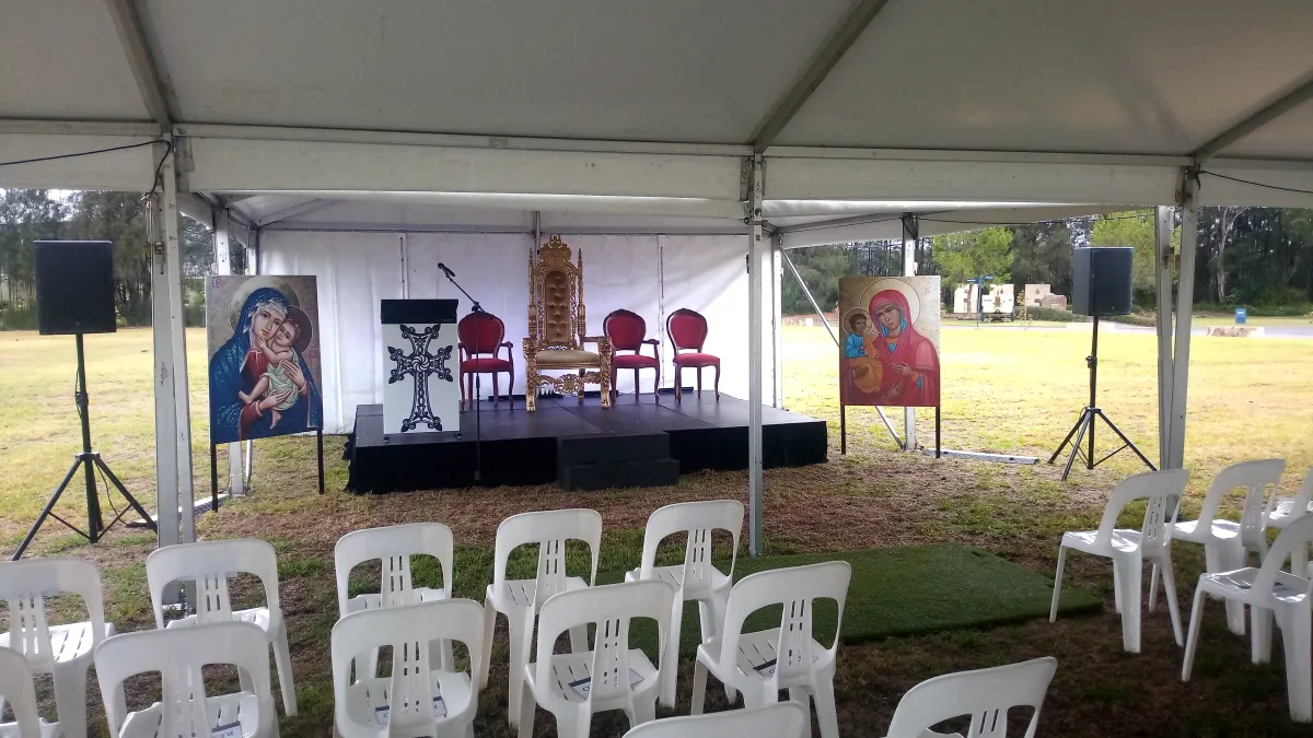 Portable outdoor PA system with point-source speakers on tripod stands and a gooseneck podium microphone.