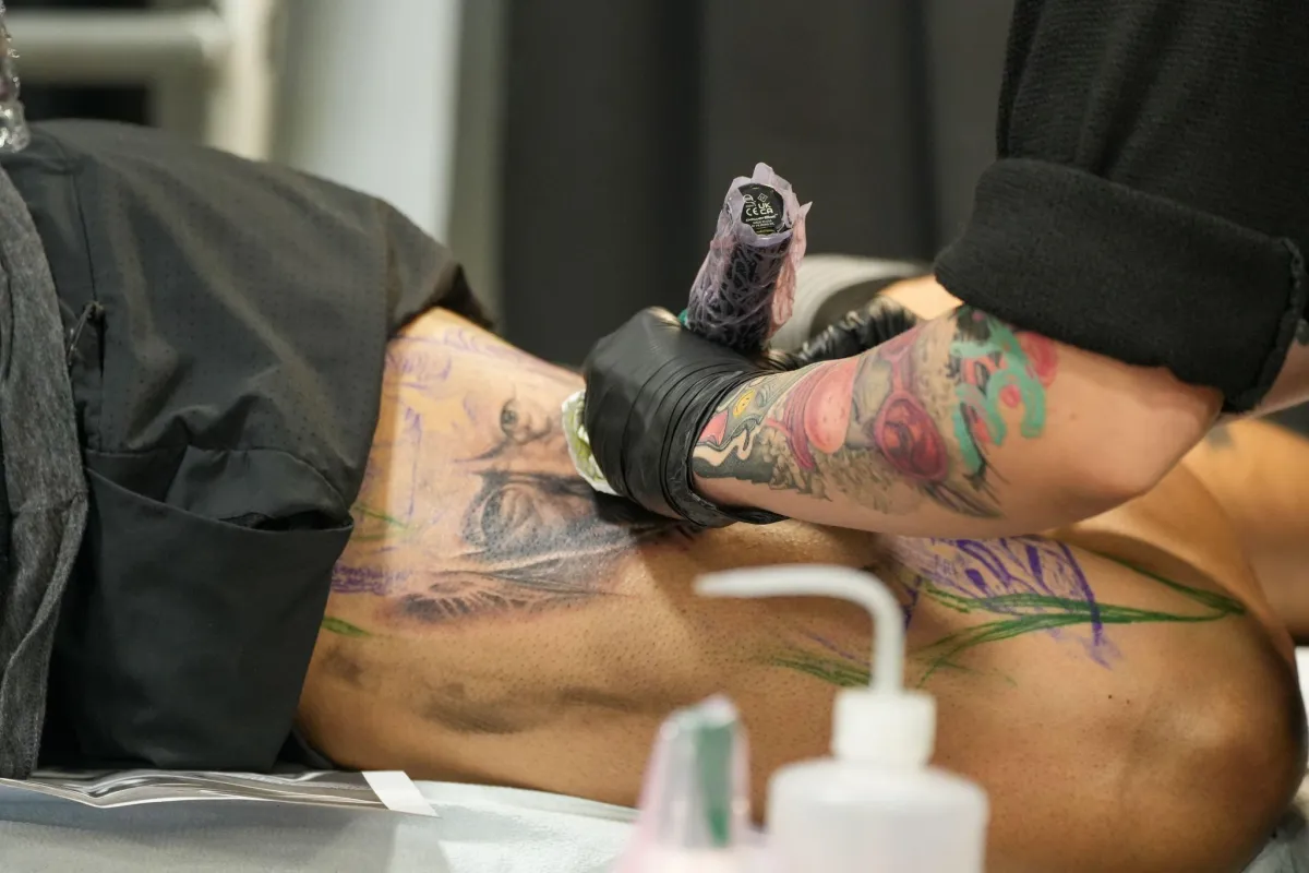 a man getting a tattoo on his leg