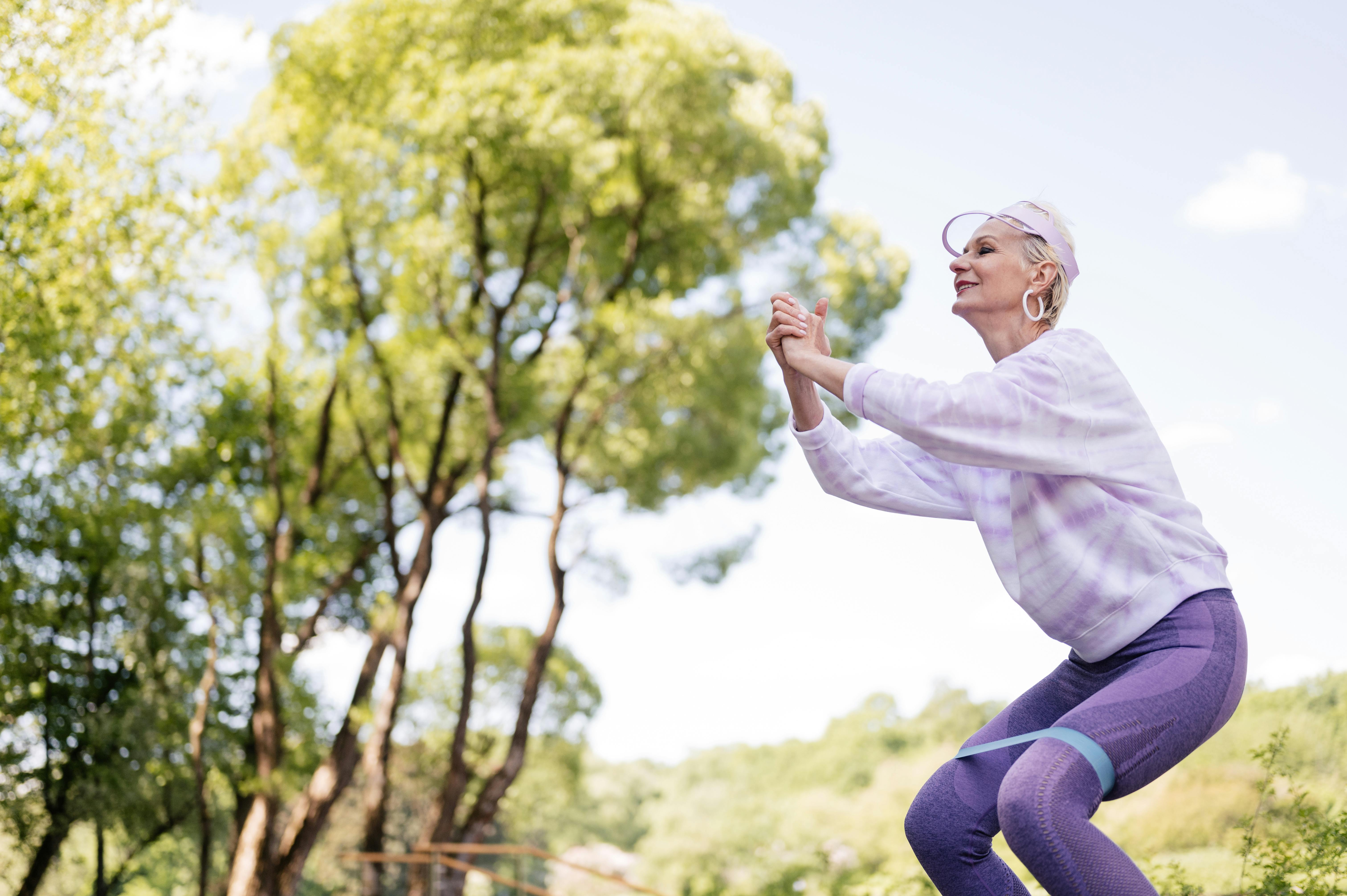 Older adult doing sit-to-stands or resistance band exercises