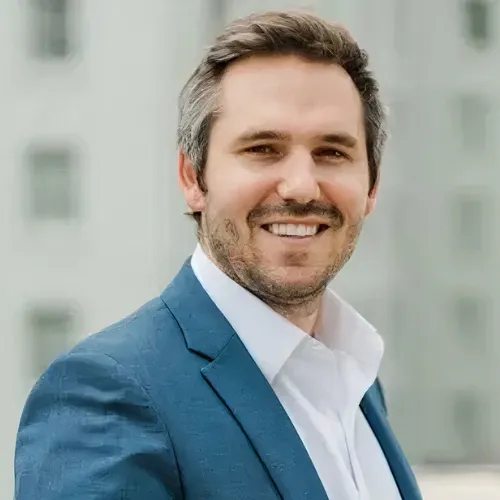 Headshot of Dylan Yesso, client of Automations Club, smiling in a professional suit.