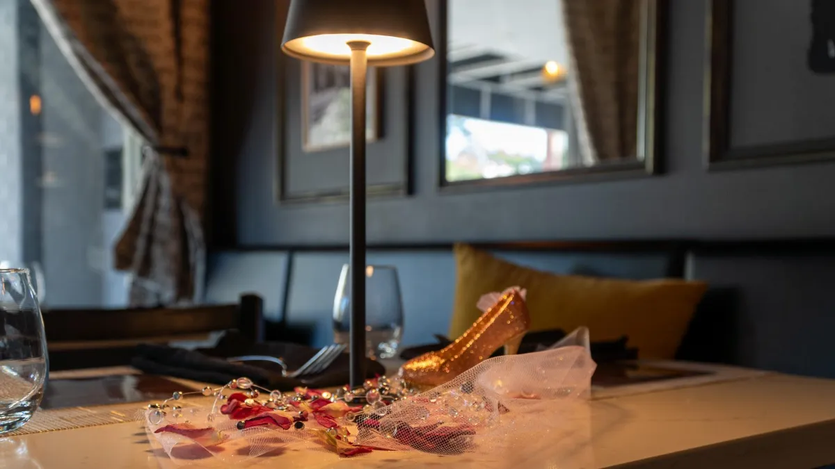 Intimate candlelit dining scene with mahogany finishes and a glass of red wine