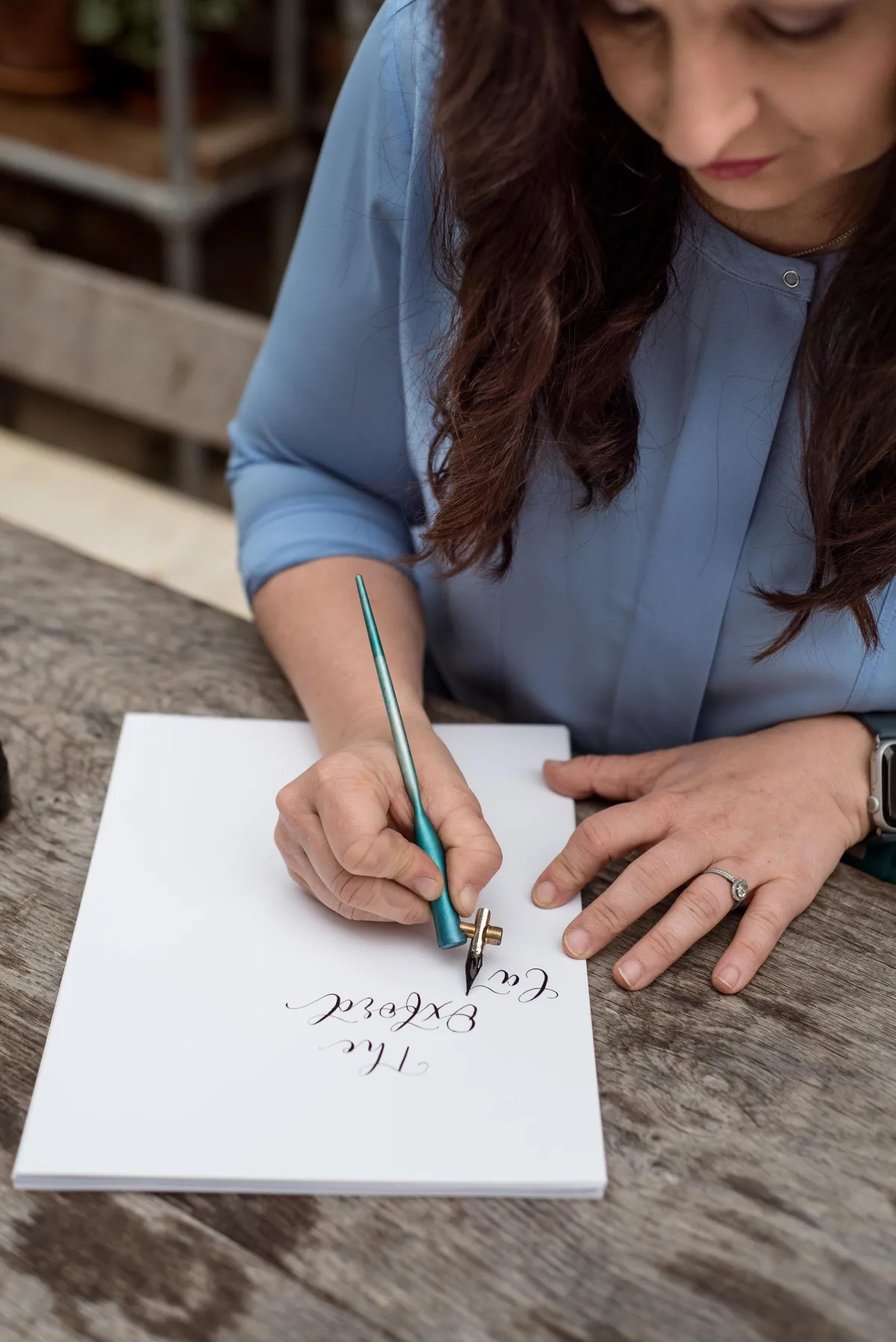 The Oxford Calligrapher holding a pointed pen