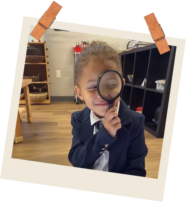 Children using magnifying glass to inspect leaves at Hopscotch Academy