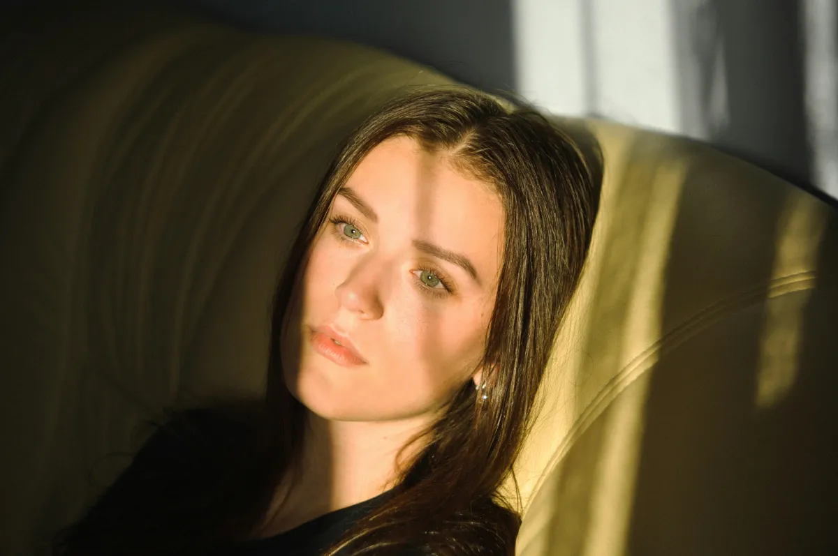 woman sitting in front of a window staring outside