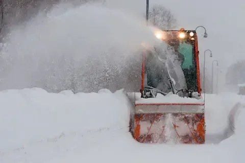 Snow plow clearing deep residential street after winter storm in Rochelle