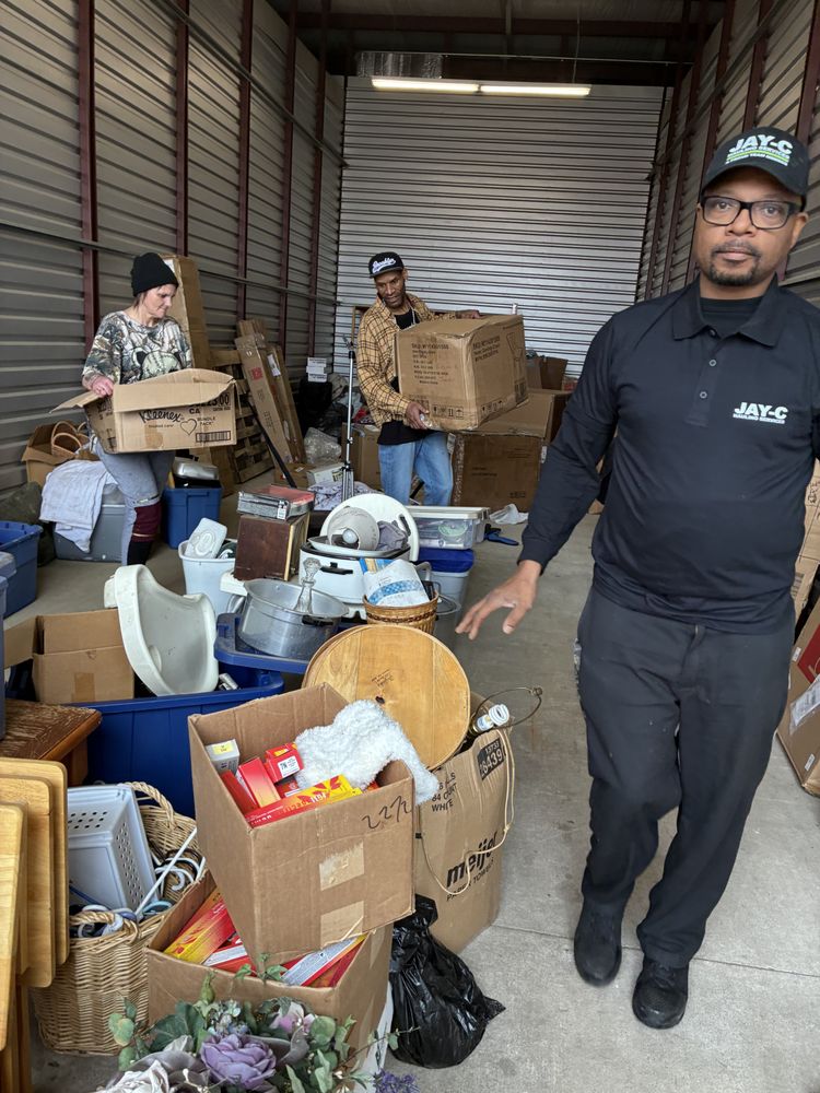 man in red blue and white plaid dress shirt and blue denim jeans standing beside black