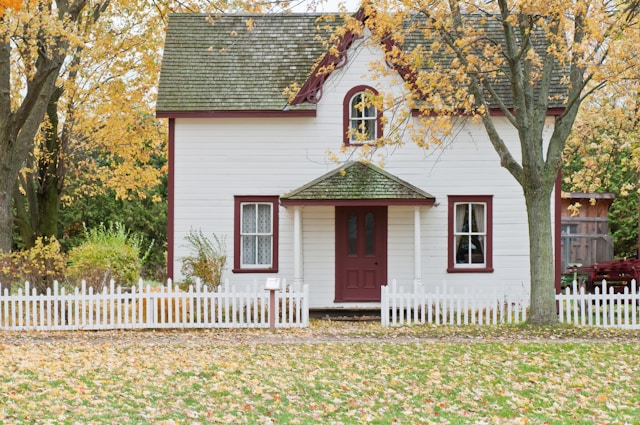 Home with white siding and a red door