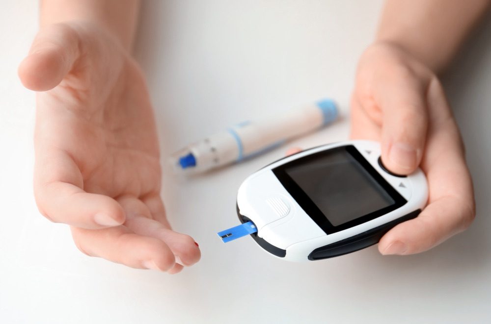 A person checking their blood sugar with a monitoring device
