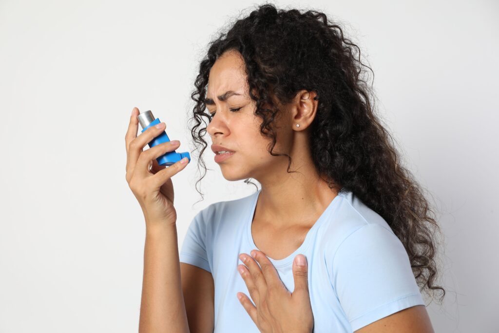 A woman blowing her nose with a tissue